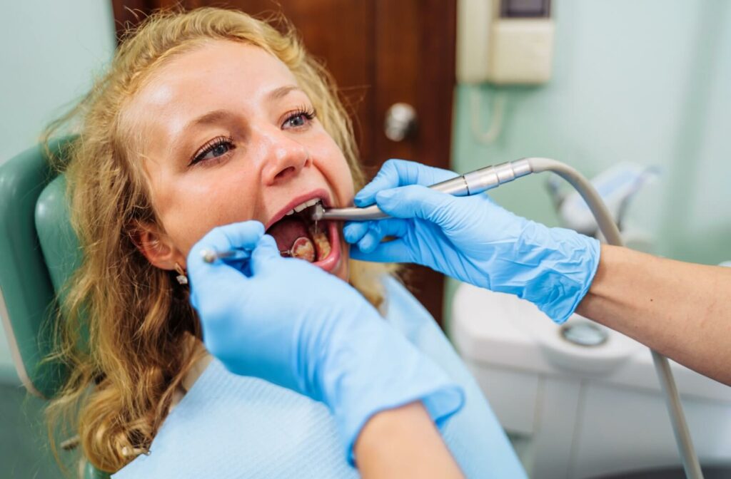 A dentist carefully removes the decay from a child's tooth.