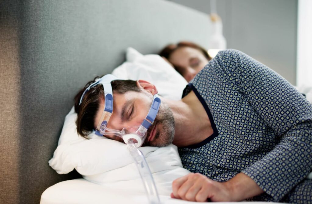 Man sleeping with CPAP mask for sleep apnea.